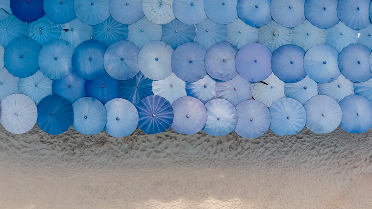 insight-credit-premiums-blue-umbrellas-beach-746-419.png